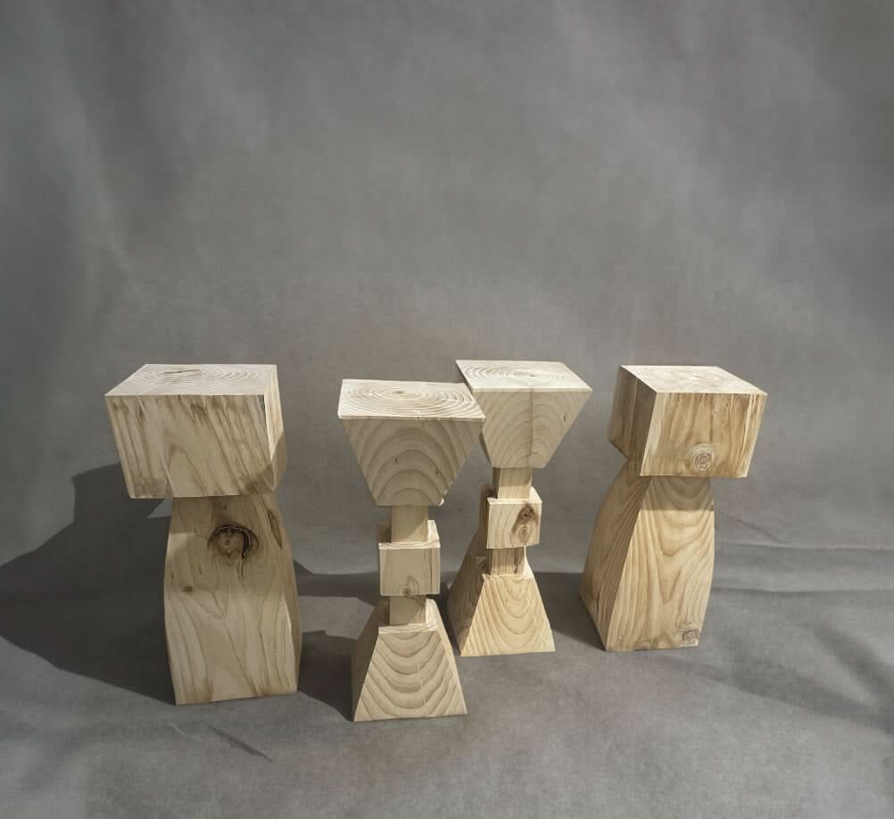 Set of 4 natural wood kitchen stools with unique geometric bases and solid wood tops.
